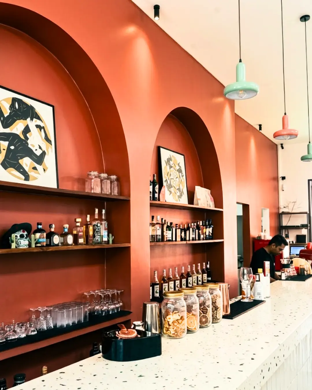 The warm coral interior and bar at Mezcal